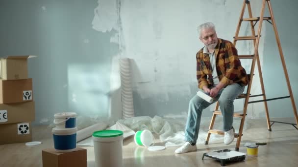 Tired Elderly Man Sitting Ladder Calling Master Repair Apartment Using — Vídeos de Stock