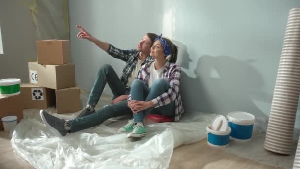 Yorgun Genç Bir Çift Yerde Oturup Çalışmalarının Sonuçlarına Bakıyor Sarılıyorlar — Stok video