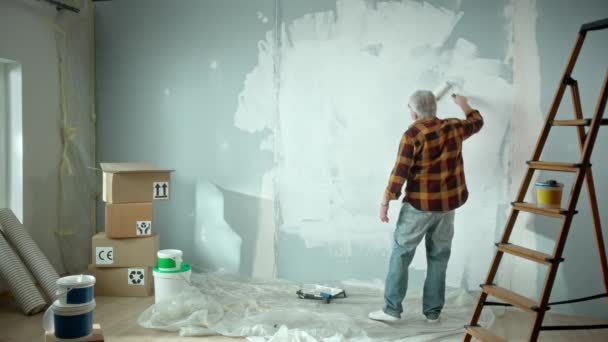 Oudere Man Schildert Muur Met Witte Verf Met Behulp Van — Stockvideo