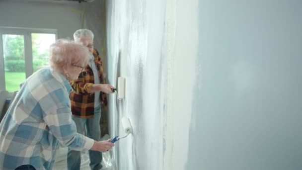 Літній Чоловік Жінка Малюють Стіну Білою Фарбою Використовуючи Валики Фарби — стокове відео