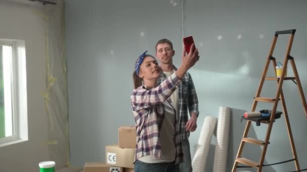 Genç Çift Kırmızı Cep Telefonlarını Kullanarak Video Görüşmesi Yapıyor Ekose — Stok video