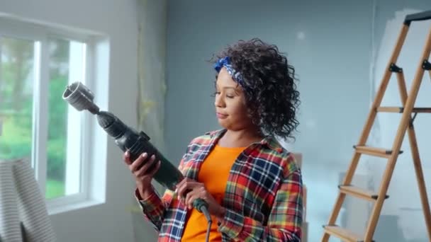 Mujer Afroamericana Joven Enciende Perforador Eléctrico Con Boquilla Para Taladrar — Vídeo de stock