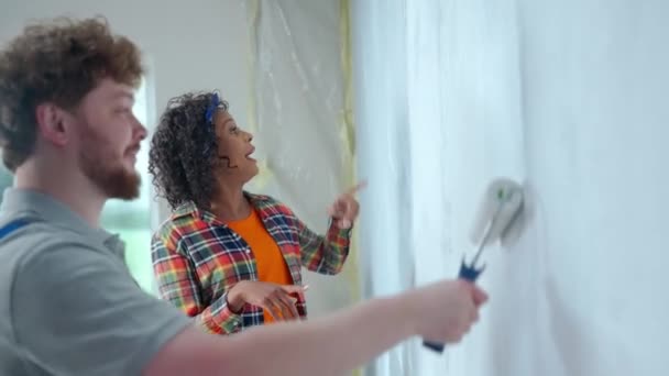 African American Woman Showing Gesture Male House Painter Painting Wall — Stock Video