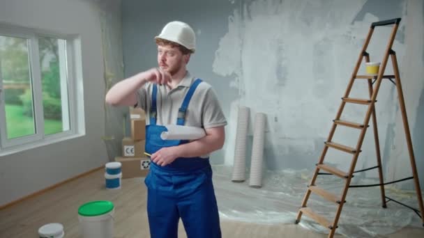 Male Foreman Looking Large Sheet Apartment Plan Thinking Repair Project — Vídeo de Stock