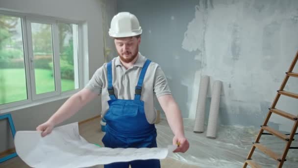 Male Foreman Looking Large Sheet Apartment Plan Thinking Repair Project — Stockvideo