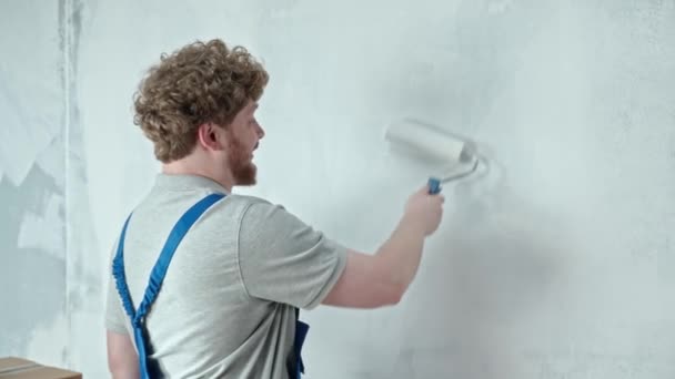Ustabaşı Mavi Tulumlu Boyacı Boya Silindiri Kullanarak Duvarı Beyaz Boyayla — Stok video