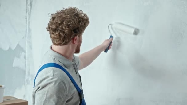 Polier Oder Maler Blauen Baukleidern Bemalt Die Wand Mit Weißer — Stockvideo