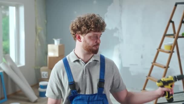 Repairman Worker Blue Construction Overalls Demonstrating How Electric Drill Works — Stockvideo