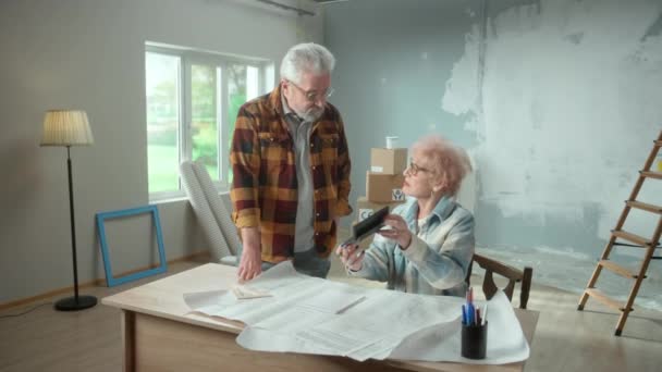 Elderly Man Woman Calculating Expenses Repairing Apartment Calculator Aged Couple — Stockvideo