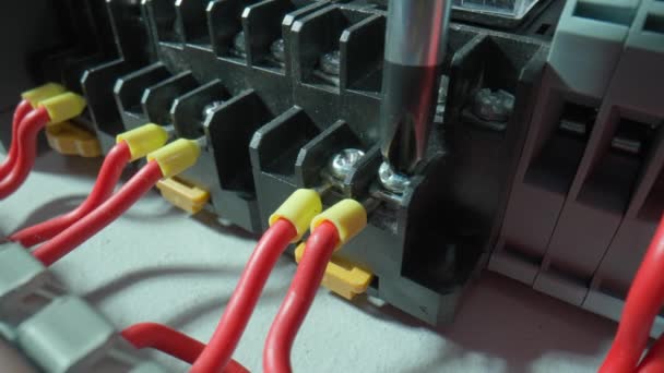 灰色塑料电气面板 有许多红线和黄色衬套发条 螺丝刀的闭合是用螺丝固定金属丝 电气车间的高压电源开关 — 图库视频影像