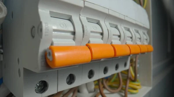 White electrical panel with many wires, electrical parts, automatic switches, breakers, residual current devices, fuses, terminals. High voltage automatic breaker switch, close up. Electric power