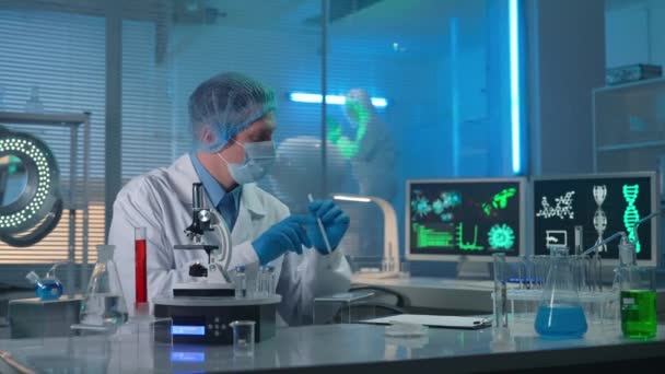 Modern Medisch Onderzoekslaboratorium Onderzoeker Onderzoekt Steekproef Een Microscoop Tweede Wetenschapper — Stockvideo