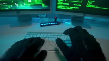 Hacker siyah eldivenlerle ellerini uzatıyor ve bir bilgisayar klavyesine şifre kırıyor. Yeşil program kodlu bilgisayar ekranı. Dosyaları flash diske kopyala. Gardiyan feneri yakar ve...