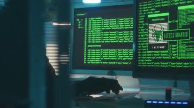 Hacker in a white mask is typing on a computer keyboard and cracking a password. Access denied, then to access granted. A man in a black hoodie and gloves is hacking security systems. The mask