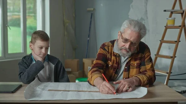 Grandpa Planning Repairs Making Notes Project Pencil Ruler Grandson Sits — Foto Stock