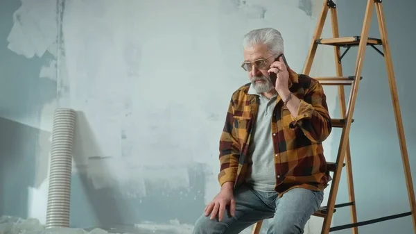 Tired Elderly Man Sitting Ladder Calling Master Repair Apartment Using — Fotografia de Stock