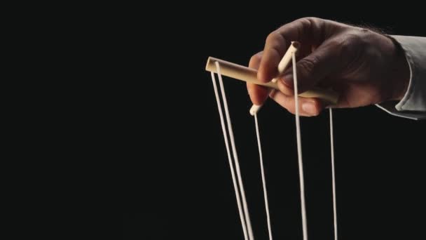 木偶手拿着木棍和绳子控制木偶 木偶画家控制和拉线的黑色背景 管理的概念 — 图库视频影像