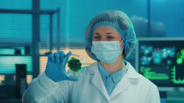 Eine Wissenschaftlerin Untersucht Eine Petrischale Mit Einer Gefleckten Grünen Probe — Stockvideo