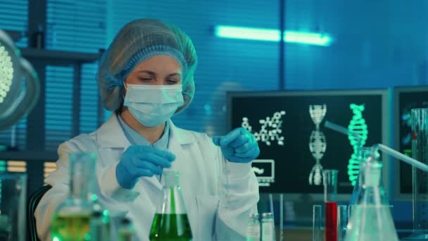 Een Vrouwelijke Wetenschapper Pipetteert Een Groene Vloeistof Een Glazen Reageerbuis — Stockvideo