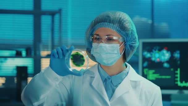 Μια Γυναίκα Επιστήμονας Εξετάζει Ένα Τρυβλίο Petri Ένα Στικτό Πράσινο — Αρχείο Βίντεο