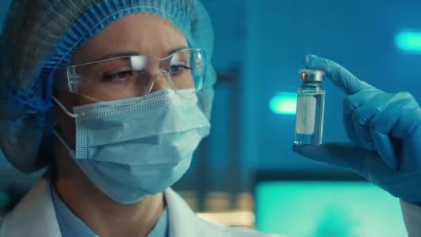 Woman Examines Glass Vial Vaccine Portrait Female Doctor Goggles White — Vídeos de Stock