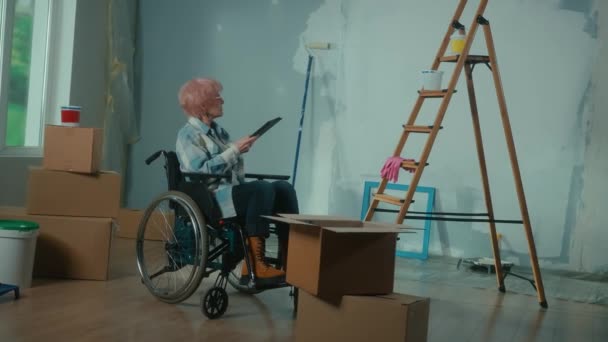 Elderly Disabled Woman Moves Wheelchair Plans Renovation Using Digital Tablet — Stockvideo