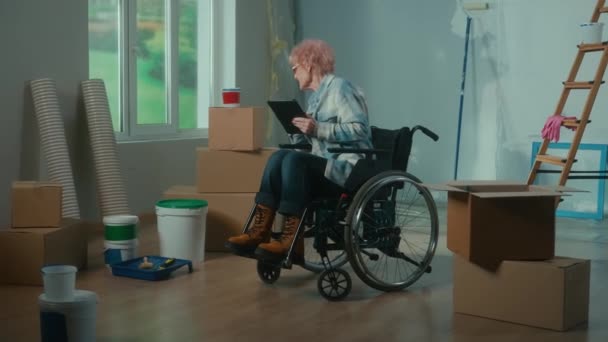 Elderly Disabled Woman Moves Wheelchair Plans Renovation Using Digital Tablet — Vídeos de Stock