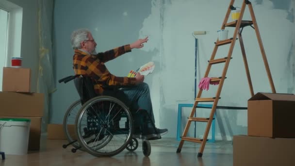 Elderly Disabled Man Moves Wheelchair Looks Palette Colors Pensioner Plans — Stockvideo