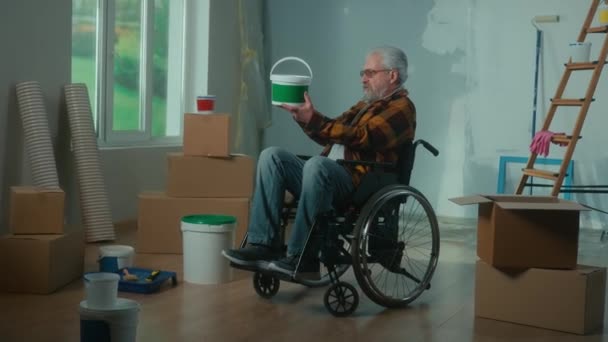 Elderly Disabled Man Moves Wheelchair Takes Bucket Paint Roller Plans — Stockvideo