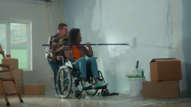 Beyaz bir adam, tekerlekli sandalyedeki Afro-Amerikalı bir kadını itiyor ve o da duvarı boyamak için uzun bir silindir kullanıyor. Genç bir çift odada tamirat yapar ve neşeyle güler. Yenileme konsepti