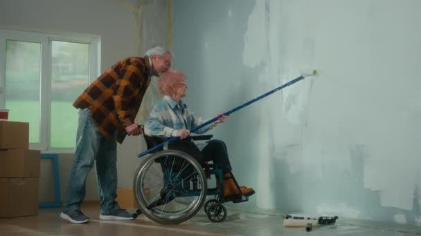 Elderly Couple Doing Repairs Room Aged Woman Wheelchair Paints Wall — Αρχείο Βίντεο