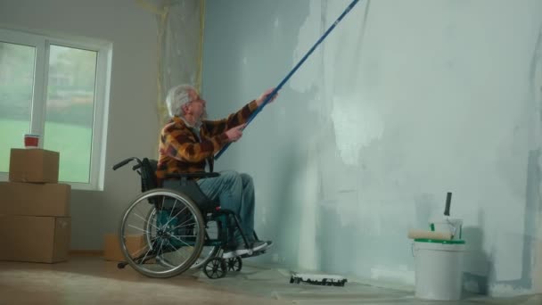 Elderly Man Wheelchair Paints Wall White Paint Using Long Roller — Stock Video