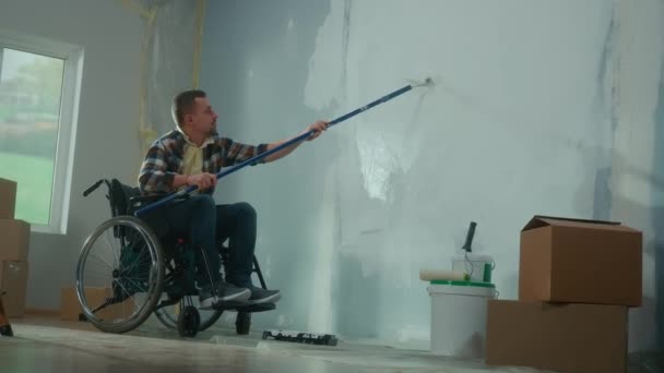 Ένας Νεαρός Αναπηρικό Καροτσάκι Ζωγραφίζει Έναν Τοίχο Λευκή Μπογιά Χρησιμοποιώντας — Αρχείο Βίντεο