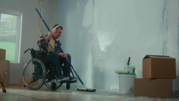 Ein Junger Mann Mit Weißen Kopfhörern Rollstuhl Bemalt Mit Einer — Stockvideo