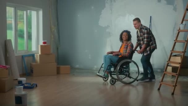 White Man Rolls African American Woman Room Wheelchair Young Couple — стокове відео