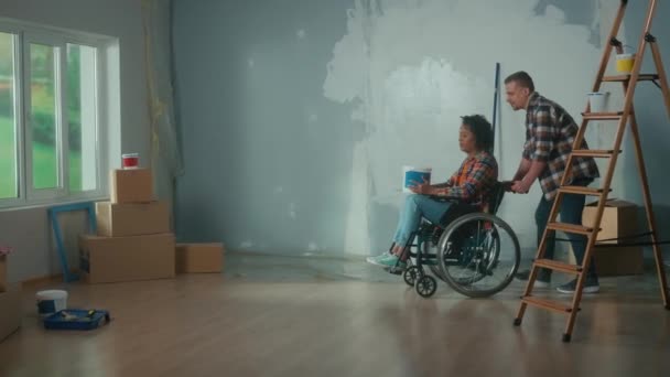 White Man Wheeling African American Woman Room Wheelchair Bucket Paint — 图库视频影像