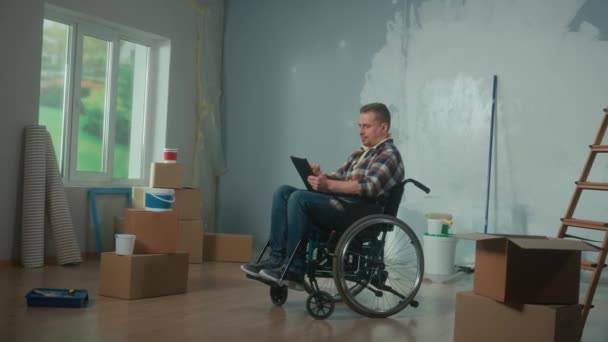 Ung Man Rullstol Planerar Reparationer Med Hjälp Digital Surfplatta Handikappade — Stockvideo