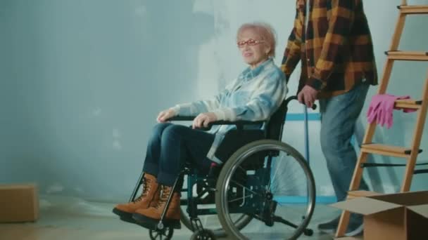 Elderly Man Wheeling Older Woman Wheelchair Room Elderly Family Couple — Stockvideo