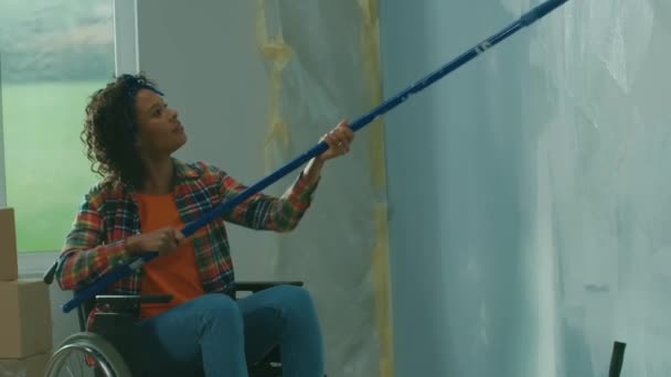 Одна Афроамериканська Жінка Інвалідному Візку Малює Стіну Білою Фарбою Використовуючи — стокове відео
