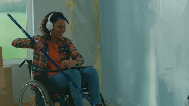 Uma Mulher Afro Americana Fones Ouvido Brancos Uma Cadeira Rodas — Vídeo de Stock