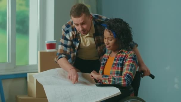White Man African American Disabled Woman Wheelchair Looking Apartment Project — Vídeo de Stock