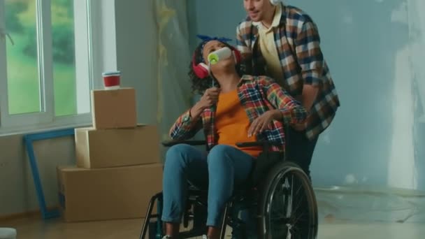 White Man Wheeling African American Woman Wheelchair Room Young Couple — Vídeos de Stock