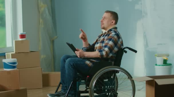Ung Man Rullstol Planerar Reparationer Med Hjälp Digital Surfplatta Handikappade — Stockvideo