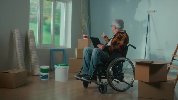 Elderly Disabled Man Moves Wheelchair Plans Renovation Using Digital Tablet — Αρχείο Βίντεο