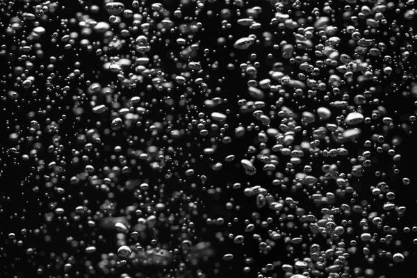 黒の隔離された背景に水中で異なるサイズの光沢のある空気の泡の多く 光の酸素泡の近くに上向きに流れます 液体の空気またはろ過 気泡の固定流れ — ストック写真
