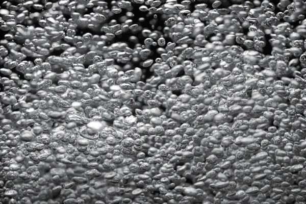 许多闪亮的气泡在水下从底部升起 被光芒照亮 黑色孤立背景上的氧气气泡流 吸气过程中气泡液体的闭合 — 图库照片