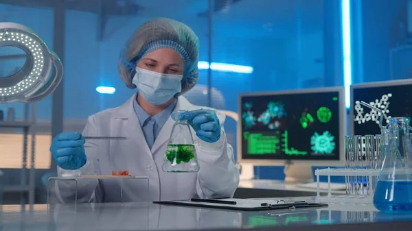 과학자는 액체가 플라스크에서 확산되는 합니다 마스크 파란색 보닛에 여성은 응답을 — 스톡 사진