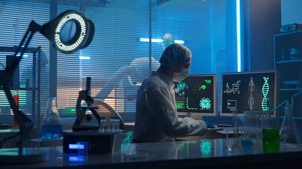 医療開発研究室 男性科学者がキーボードで入力し 研究データを入力します 試験管 フラスコ 顕微鏡を備えた現代の研究室を背景にした男性研究者 — ストック写真