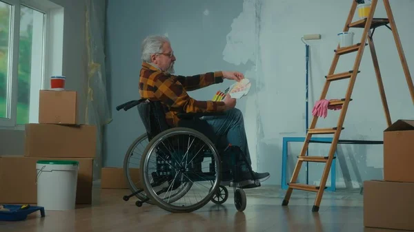 Starszy Niepełnosprawny Mężczyzna Wózku Inwalidzkim Patrzy Przez Paletę Kolorów Emeryt — Zdjęcie stockowe