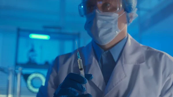 Мужчина Белом Халате Медицинской Маске Очках Голубых Перчатках Держит Шприц — стоковое фото